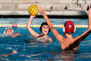 Website Photo 2 male water polo player shooting against a defender.