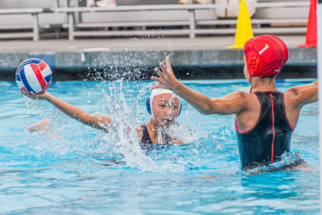Website Photo 4 female water polo player shooting against a defender.