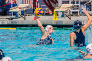 Website Photo 6 female water polo player shooting against a defender.
