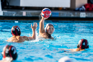 Website Photo 7 male water polo player shooting against a defender.