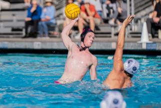 Website Photo 8 male water polo player shooting against a defender.
