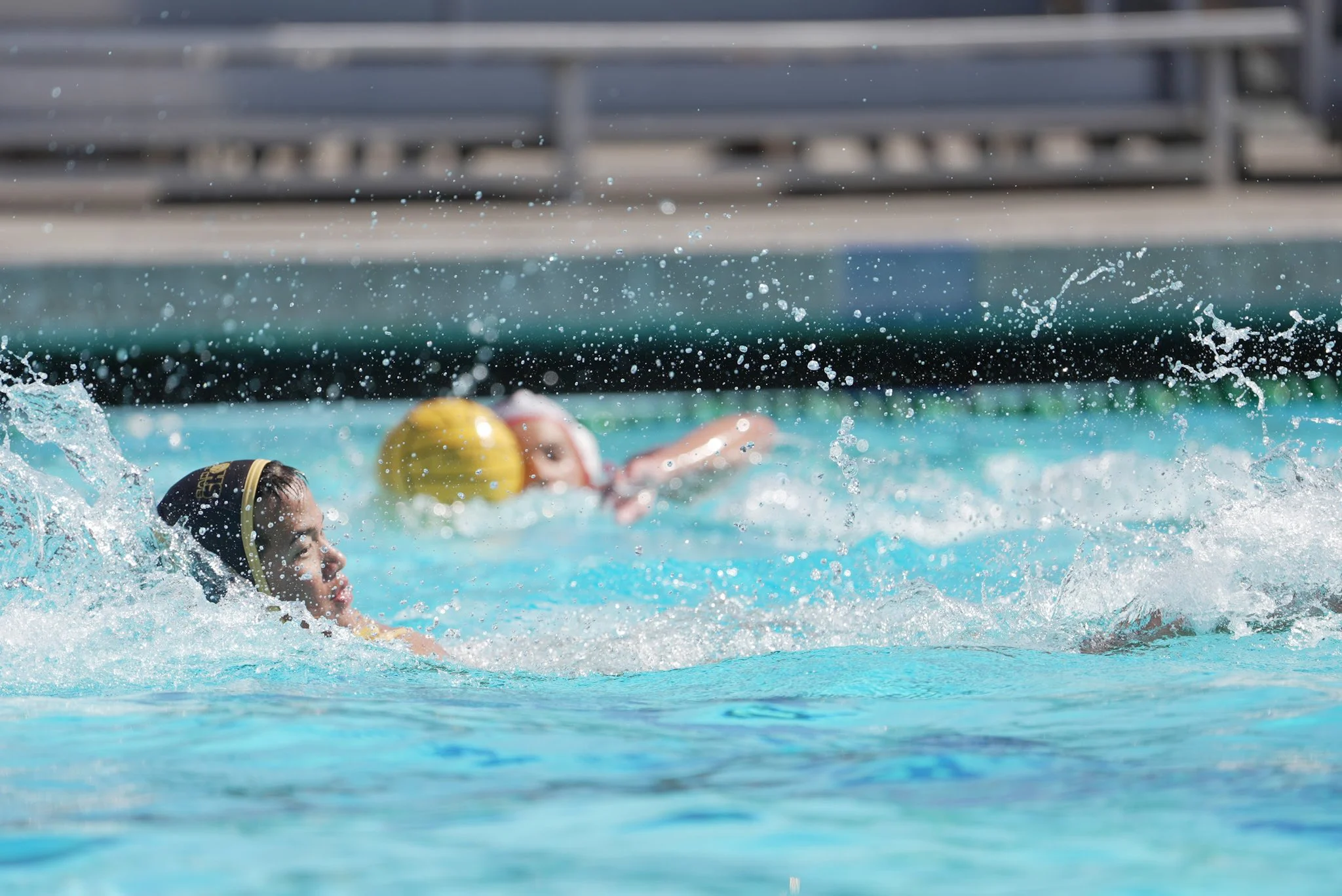 Water polo player fights through a splash of water for the ball