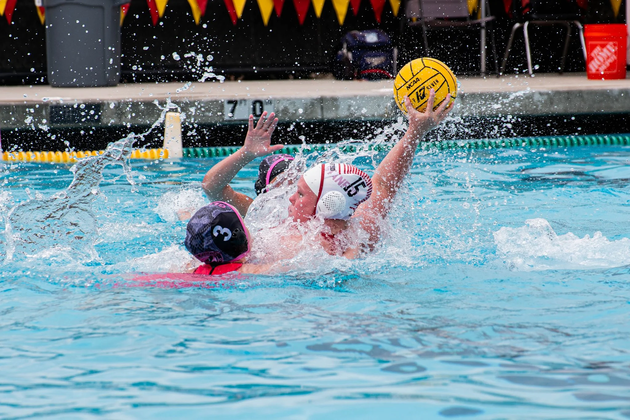 Girls water polo players battle for possession