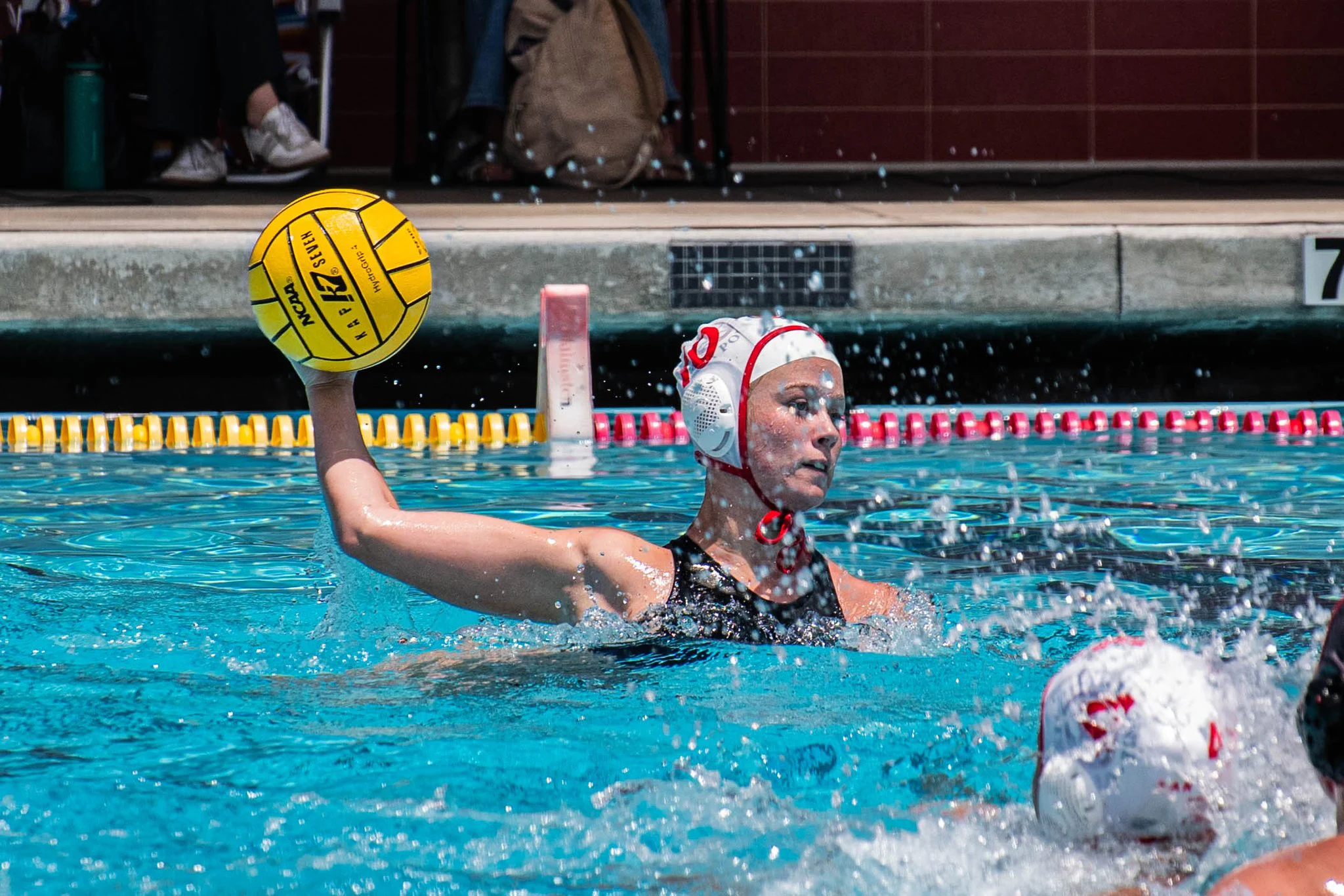 Girls water polo player drives with the ball toward goal